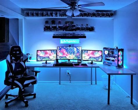 a room with three computer monitors and two gaming screens on the wall ...