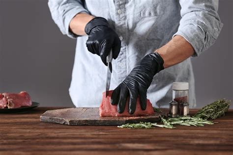 Premium Photo | Butcher cutting pork meat on kitchen