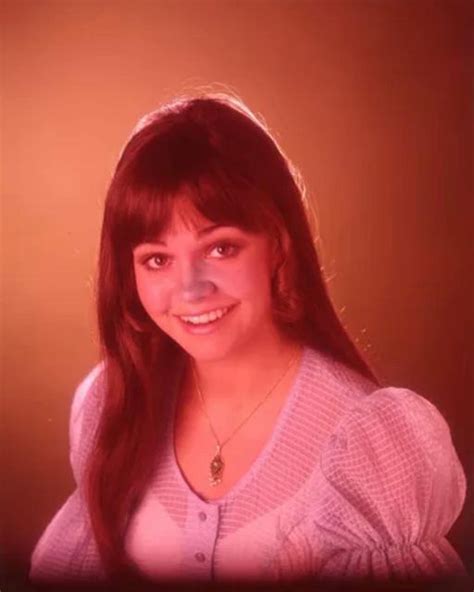 a woman with long red hair is smiling for the camera while wearing a ...