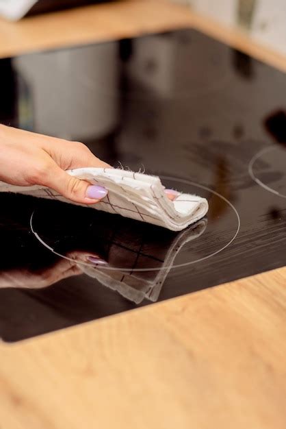 Premium Photo | Cleaning the induction hob with detergent and sponges