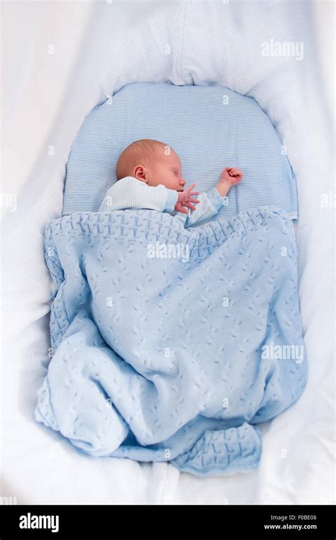 Newborn baby boy in bed. New born child sleeping under a blue knitted ...