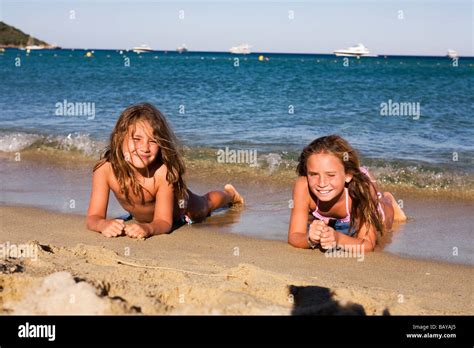 Young caucasian girls lying on the sand waiting for the waves. Plage de ...