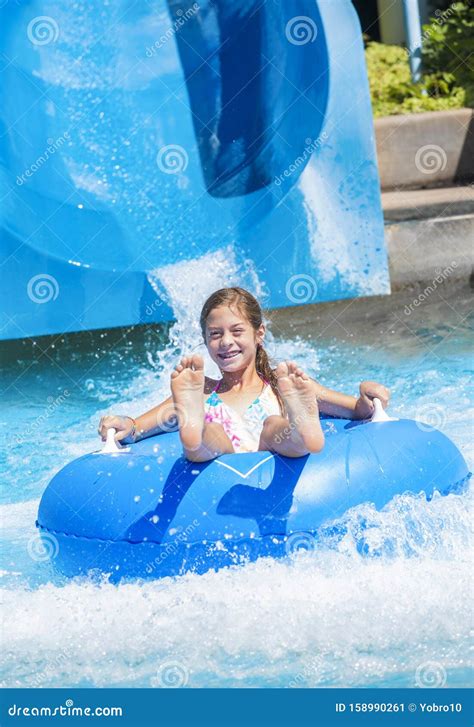 Smiling Cute Little Girl Riding Down a Water Slide at a Water Park ...