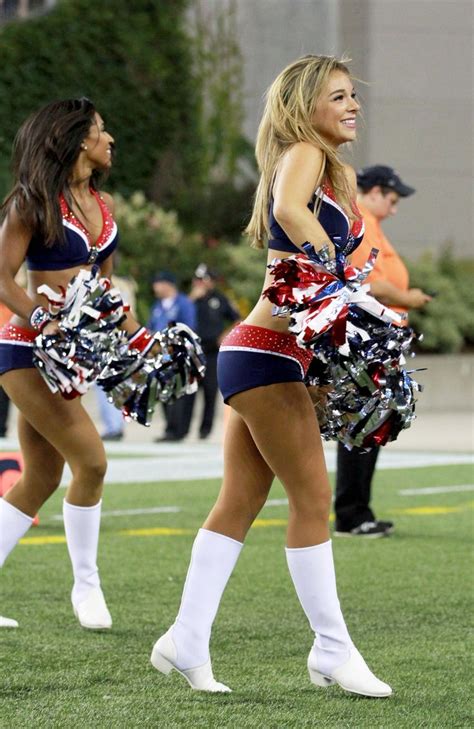 two cheerleaders in red, white and blue outfits are dancing on the field