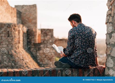 Young Man Reading a Book Outdoors Stock Image - Image of read, casual ...