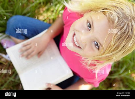 Little girl reading book outdoors Stock Photo - Alamy