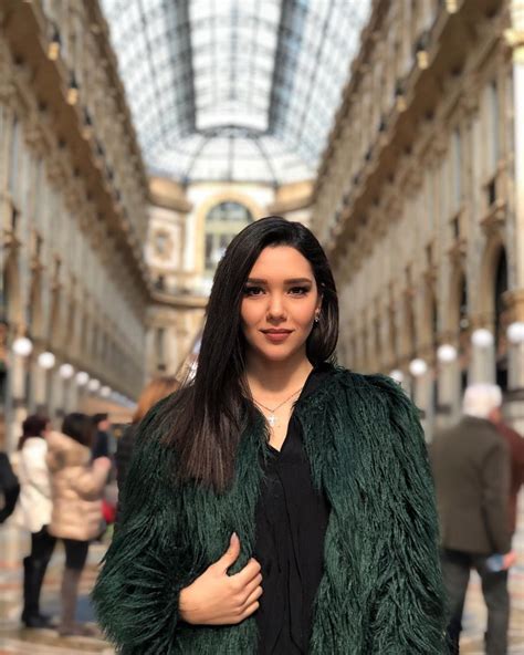 a woman is standing in the middle of an indoor shopping mall with her ...