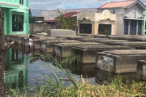 Visitors brave flooded cemeteries on All Saints' Day in Pampanga | ABS ...