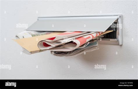 A letter and newspapers in a letterbox Stock Photo - Alamy