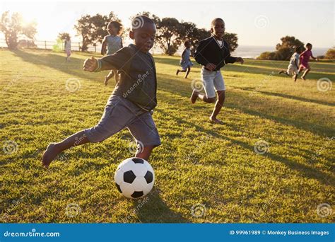 Elementary School Kids Playing Football In A Field Royalty-Free Stock ...