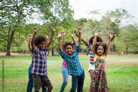 Group of African American children playing and raising their hands in ...