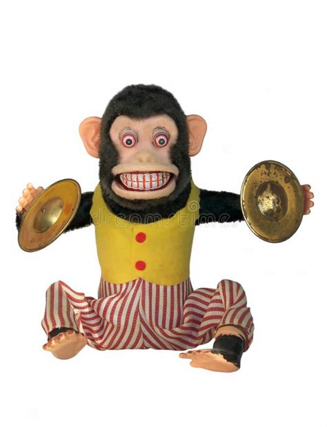 a monkey dressed in striped pants and a yellow shirt holding a brass ...