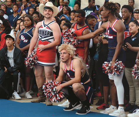 a group of cheerleaders standing next to each other in front of a crowd