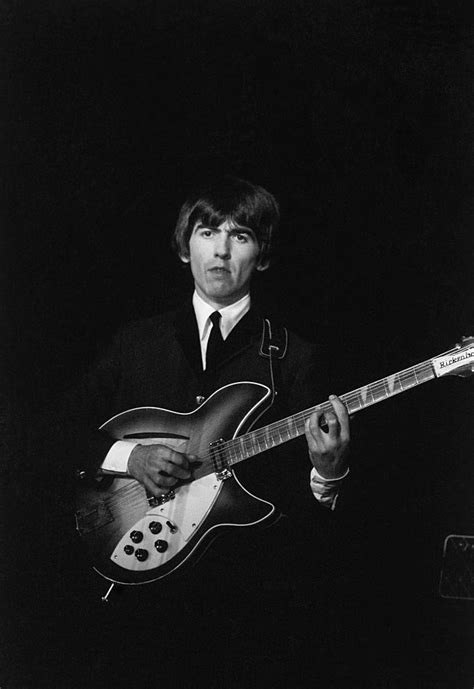 George Harrison playing his Rickenbacker 12 string guitar on stage with ...