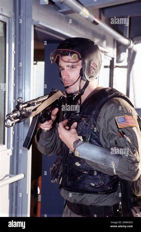 A U.S. Navy SEAL, armed with an MP5-N sub-machine gun, sets up a ...