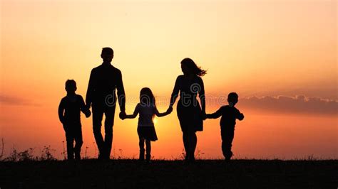 Silhouettes of Happy Family Holding the Hands in the Meadow during ...