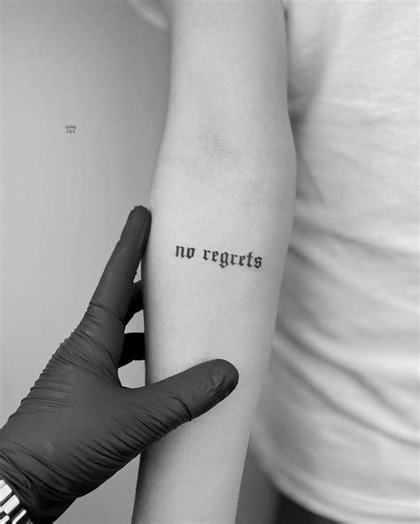 "No regrets" lettreing tattoo in gothic font, located