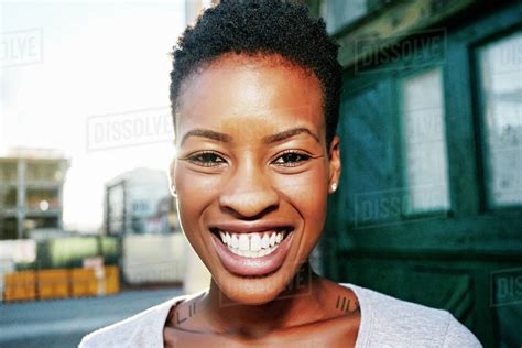 Portrait of smiling Black woman posing in city - Stock Photo - Dissolve