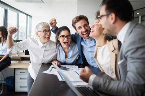 Happy business people celebrating success at company Stock Photo by nd3000