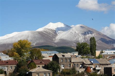 Premium AI Image | A village with a snow covered mountain in the background