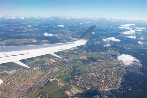 Airplane Window View Showing Wing of the Plane Flying Over Small Town ...