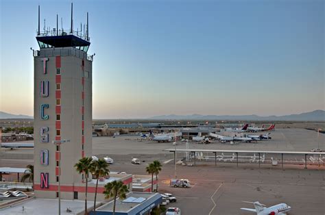 an airport with planes parked on the tarmac and palm trees in front of it