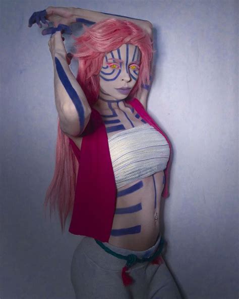 a woman with pink hair and body painted in blue and white stripes is ...