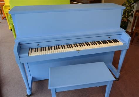 a blue piano sitting in the middle of a room