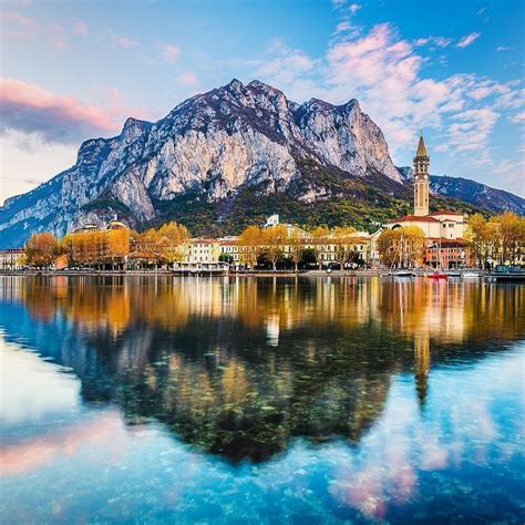 the mountains are reflected in the still water of lake luganoni, italy ...