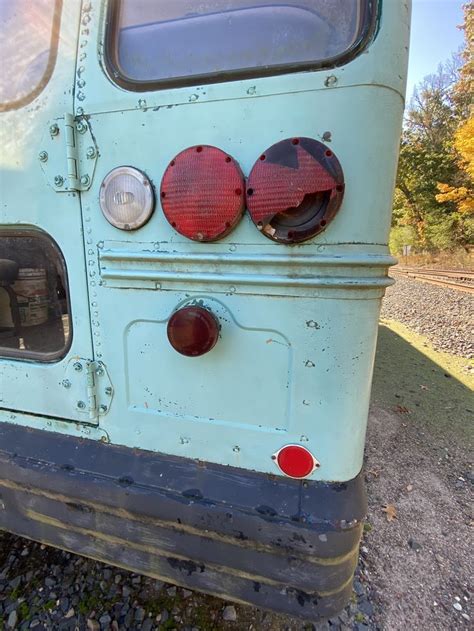 an old blue bus is parked on the side of the road