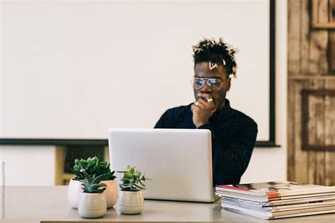 «Young Black Man Working On Laptop In Bright Minimalist Office» del ...