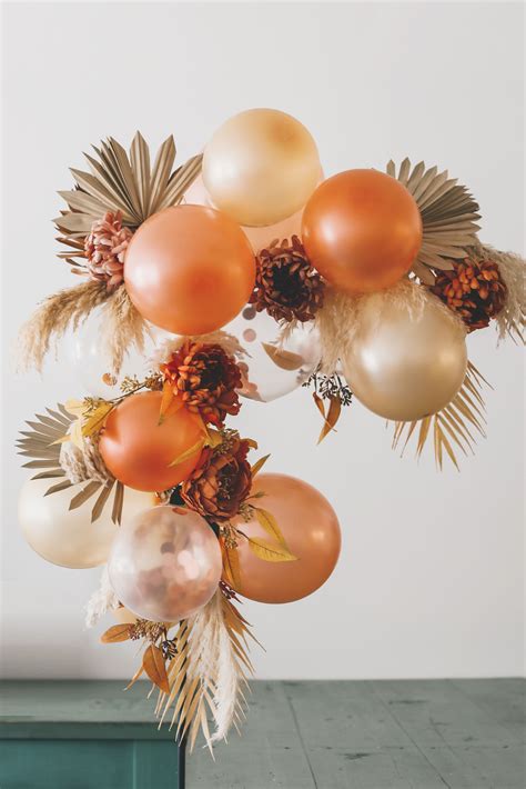 Create a simple balloon arch with dried sun palms and fake flowers from ...