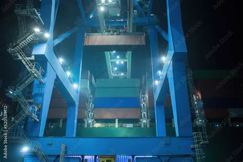 operation of container terminal at night. Unloading container ship at ...