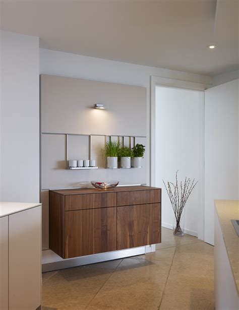 Floating walnut cabinets provide additional storage below the bulthaup ...