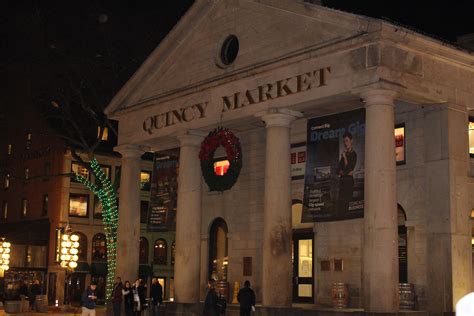 people walking in front of a building with christmas decorations on the ...