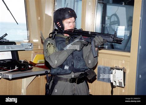 A U.S. Navy SEAL, armed with an MP5-N sub-machine gun, sets up a ...