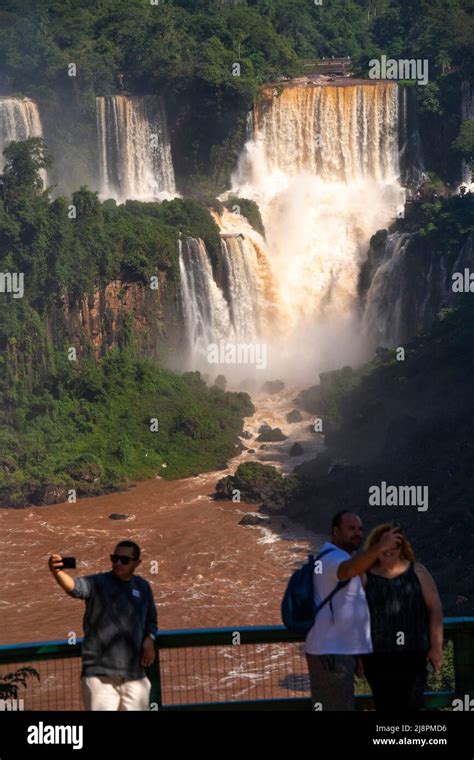 Tourists admiring the Iguazu Falls, one of the biggest falls in the ...