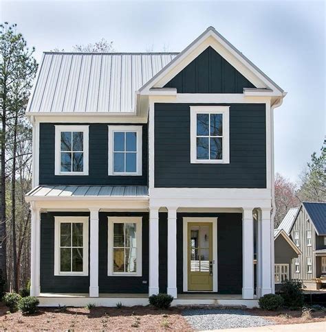 a black and white two story house with lots of windows