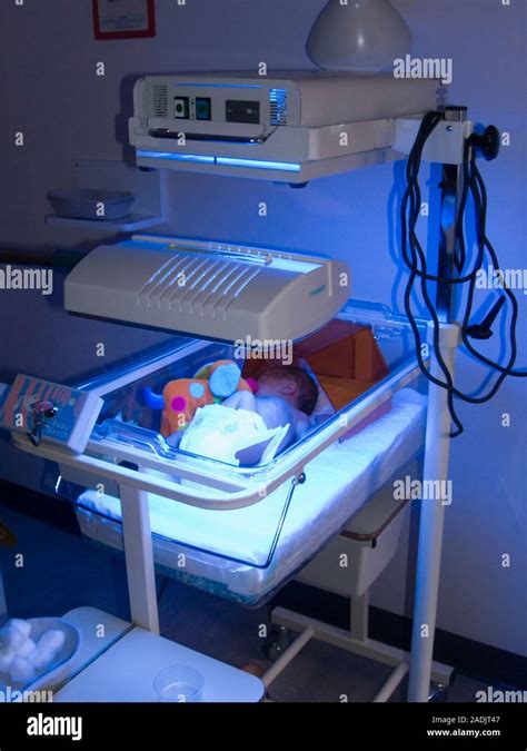 Neonatal jaundice treatment. Baby in an incubator receiving blue light ...