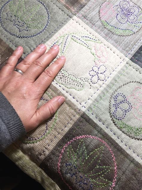 a person's hand on top of a piece of fabric with embroidered circles ...