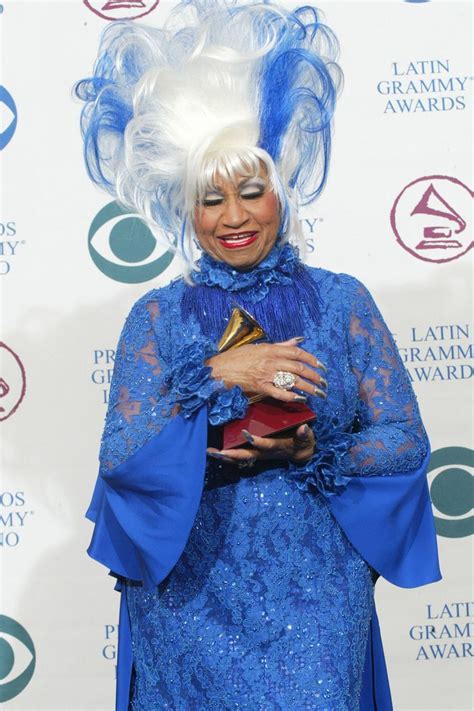 a woman in blue dress holding an award at the latina music and film awards