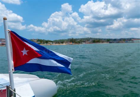 Cuba Flag Waving on Boat at Sea Near Cuban Coastline Stock Photo ...