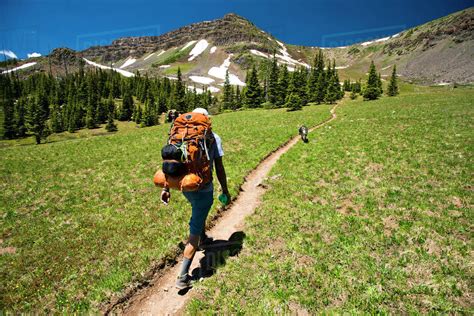 A backpacker hiking through the mountains. - Stock Photo - Dissolve