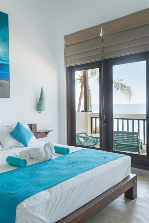 a bed with towels on top of it in front of a window overlooking the ocean