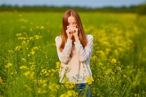 Pollen allergy, girl sneezing in a field of flowers. — Stock Photo ...