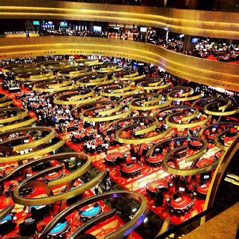 a large room filled with lots of cars and people sitting at desks in it