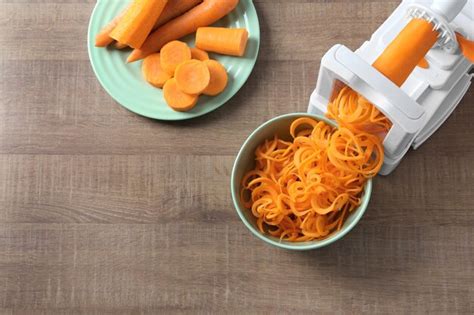 Premium Photo | Spiral vegetable slicer with carrot spaghetti on table