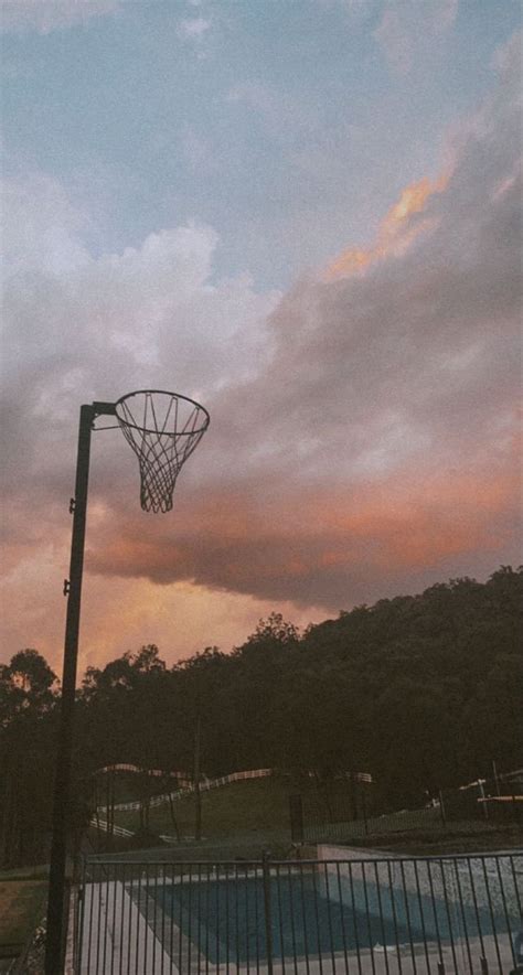 a basketball hoop is in the air above a swimming pool at sunset or ...