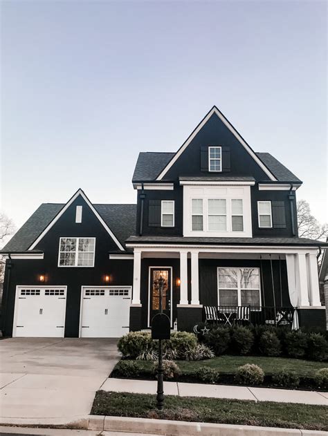 black brick house with white siding - Randi Israel