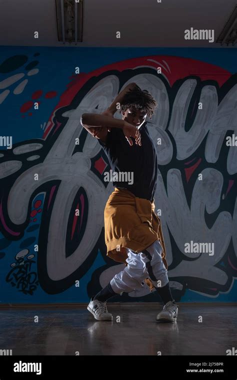 African American hip hop dancer (breakdancer) performing over graffiti ...